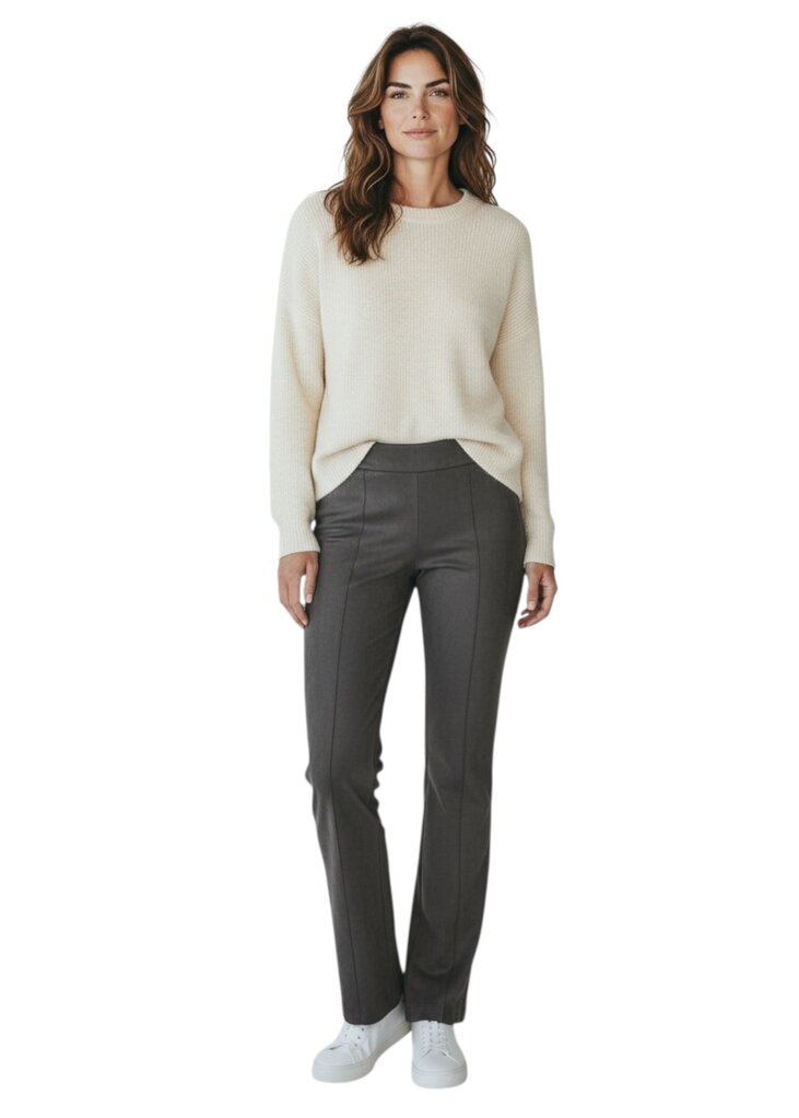 Woman wearing a cream sweater and gray pants on a white background